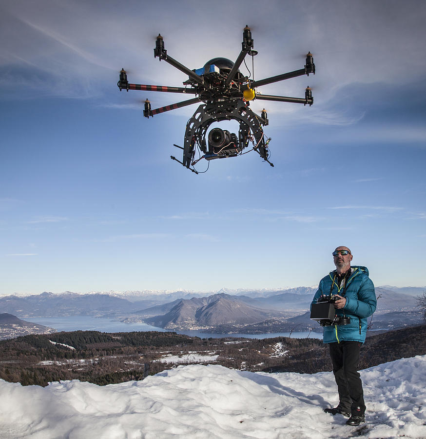 Man flying drone with camera Photograph by Buena Vista Images