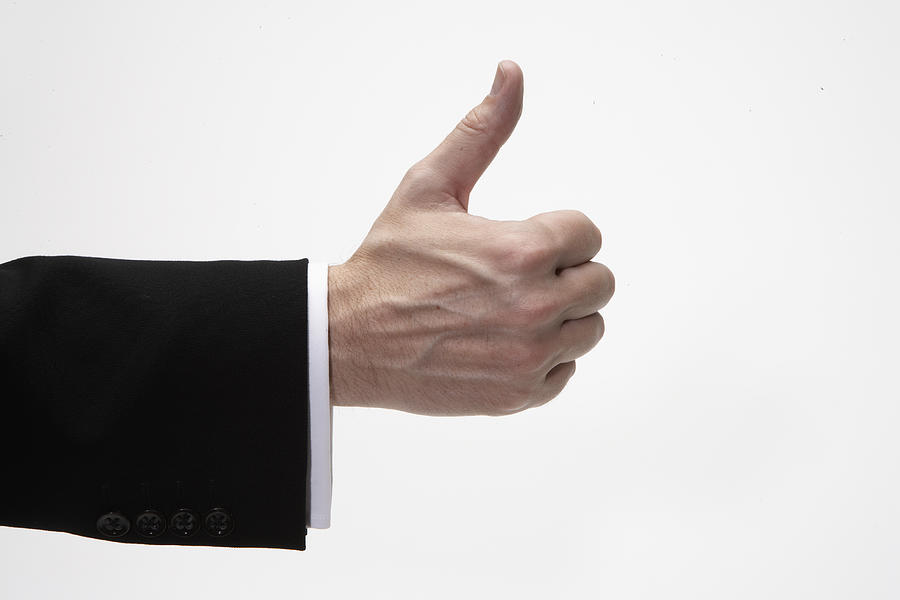 Man giving thumbs up sign, close-up of hand, side view Photograph by Thomas Northcut