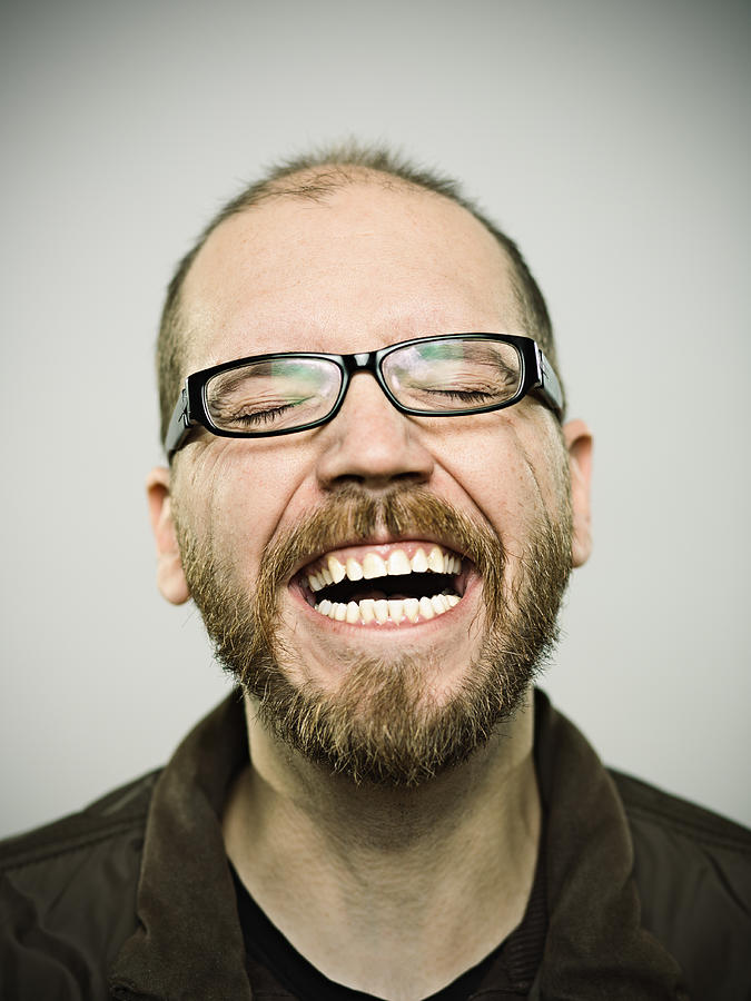 Man having a good laugh over gray background Photograph by SensorSpot