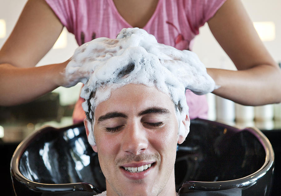 Man having his hair washed in hairdressing salon Photograph by Dimitri Otis