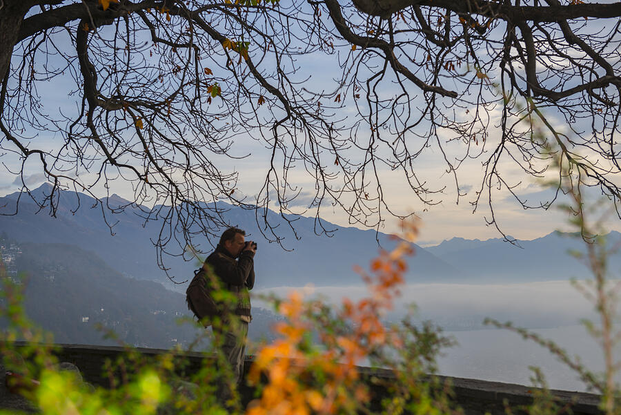 Man hiking in the nature and using a camera Photograph by Mats Silvan