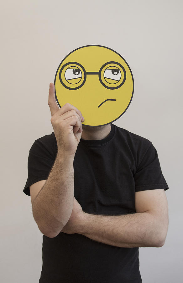 Man holding a confused emoticon face in front of his face Photograph by Malte Mueller