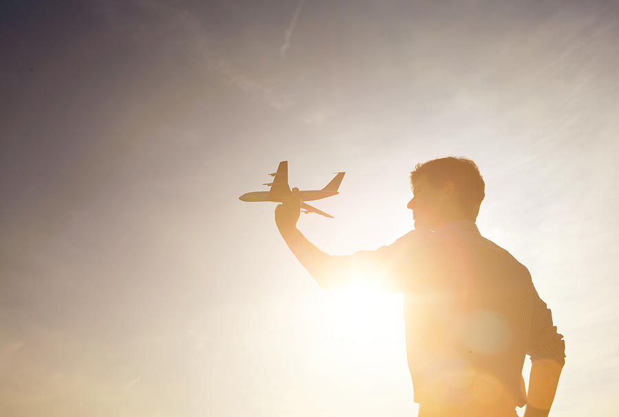 Man Holding A Model Plane Against Sunset. Photograph by Ezra Bailey