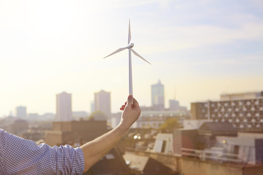 Man holding a model wind turbine. Photograph by Ezra Bailey