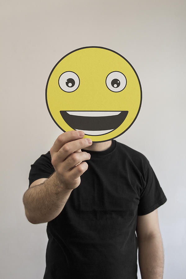 Man holding a really happy emoticon face in front of his face Photograph by Malte Mueller