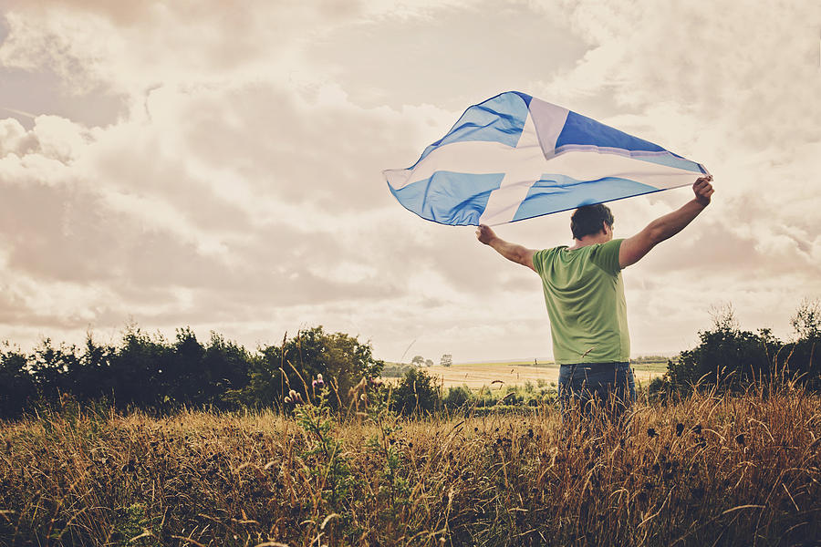 Man holding a Scottish flag Photograph by Sally Anscombe