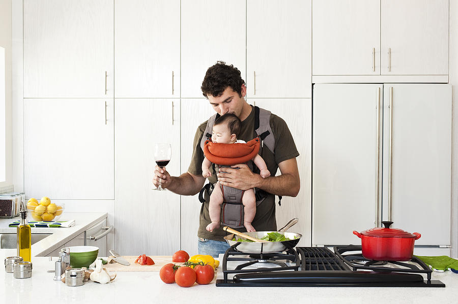 Man Holding Baby While Cooking Photograph by Karen Moskowitz