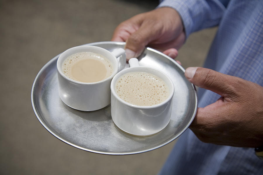 Man holding chai tea on a steel patter. Photograph by Amanda Koster Productions