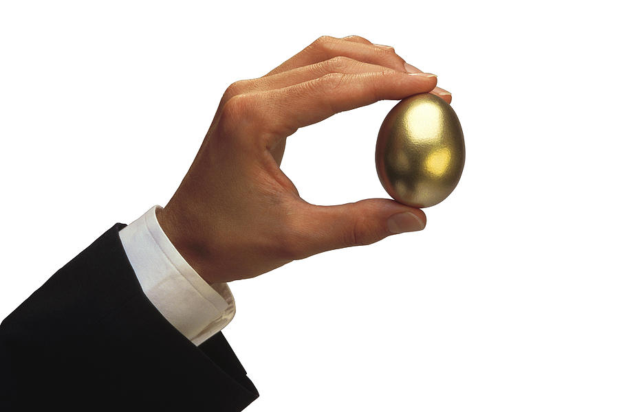 Man holding golden egg Photograph by Comstock