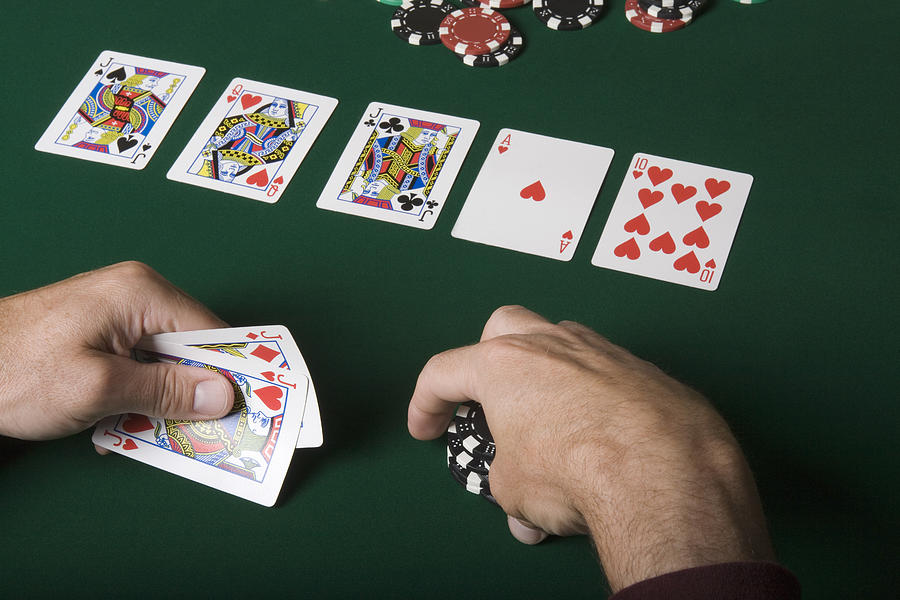 Man holding playing cards and poker chips Photograph by Jupiterimages