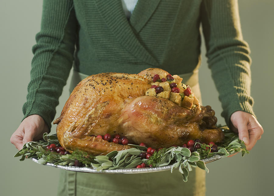 Man holding Thanksgiving turkey on decorated platter Photograph by Tetra Images