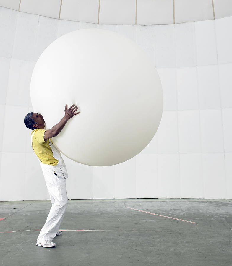 Man Holding Up Huge Balloon Photograph by Michael Blann