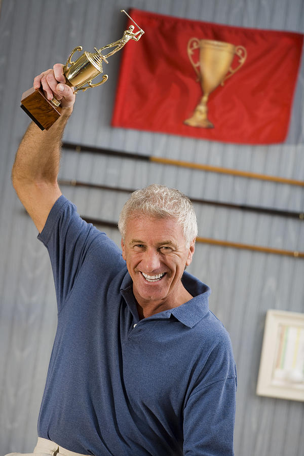 Man holding up trophy in victory Photograph by Comstock Images