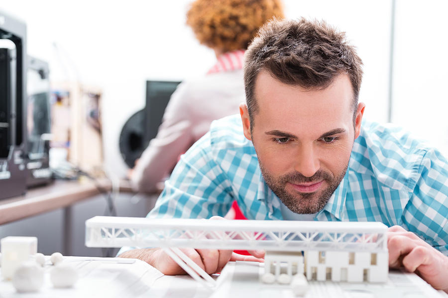 Man in 3D printer office watching printings Photograph by Izusek