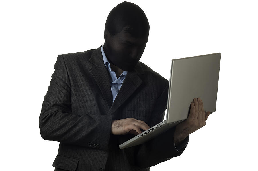 Man in a mask wearing suit holding laptop Photograph by Elabdesign