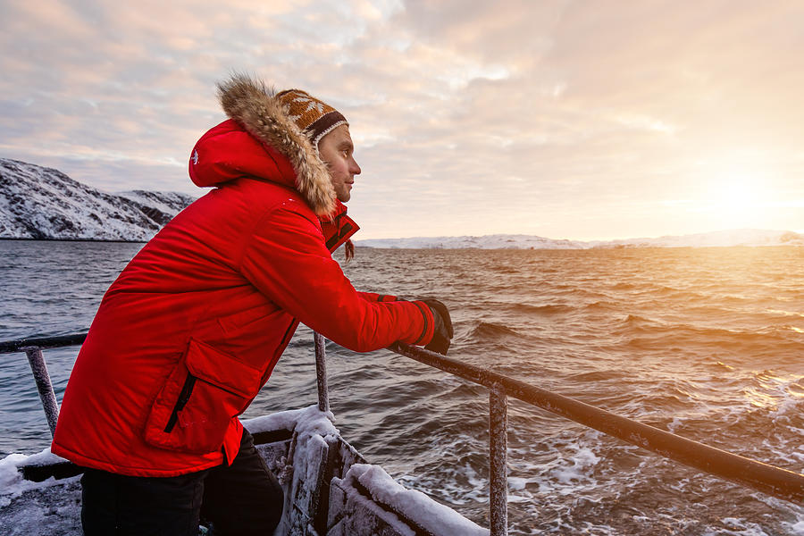 Man in a red jacket on board a ship in the winter in the Arctic Photograph by Anton Petrus