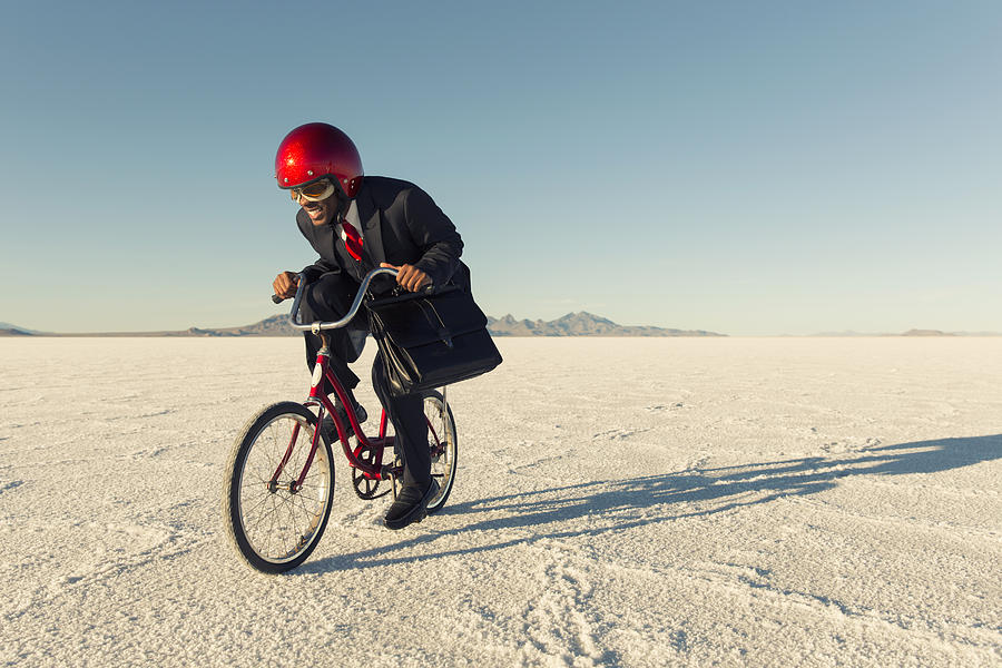 Man in Business Suit and Racing Helmet Races his Bicycle Photograph by RichVintage