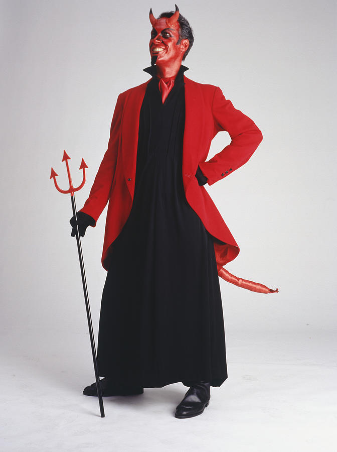 Man in devil costume standing, smiling Photograph by Photodisc