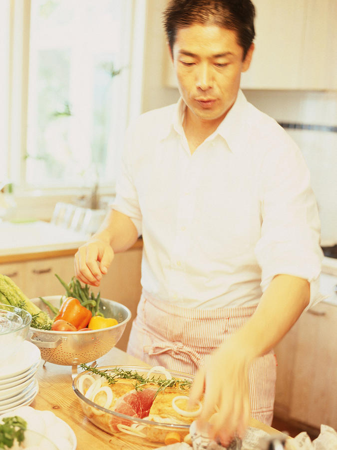 Man in kitchen preparing food Photograph by Dex Image