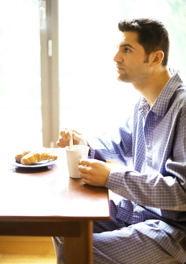 Man in nightshirt having breakfast Photograph by John Dowland