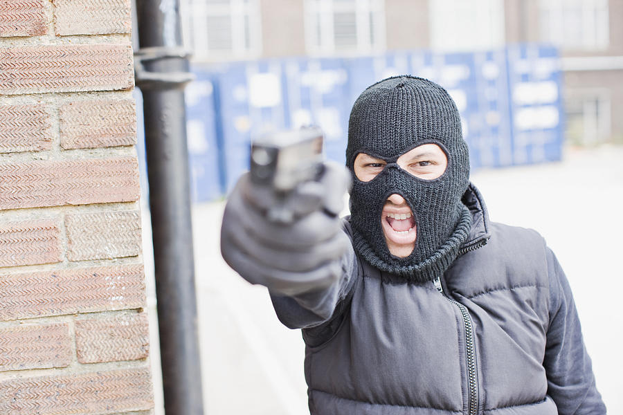 Man in skin mask holding gun Photograph by Paul Bradbury