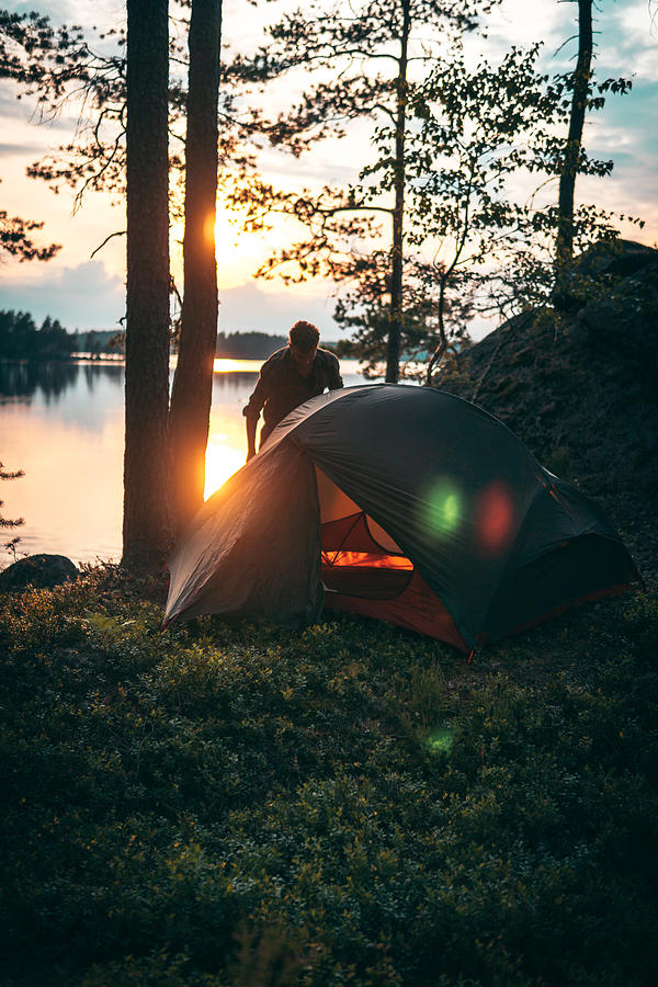 Man is standing next to the tent standing in the forest Photograph by Janiecbros
