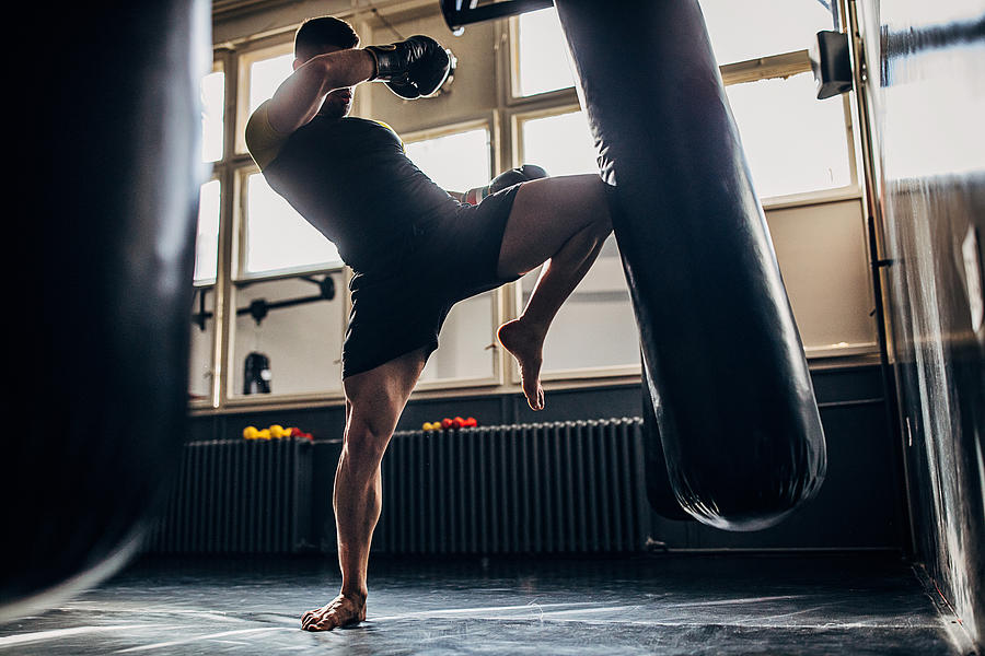 Man kick boxer training alone in gym Photograph by South_agency