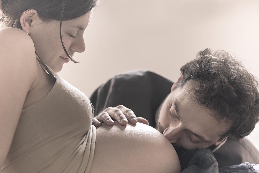 Man kissing stomach of pregnant woman Photograph by Paolomartinezphotography