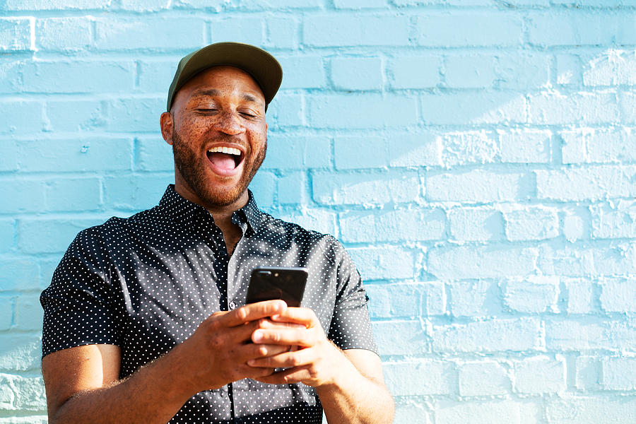 Man laughing with smart phone Photograph by Tim Robberts Man laughing with smart phone Photograph by Tim Robberts