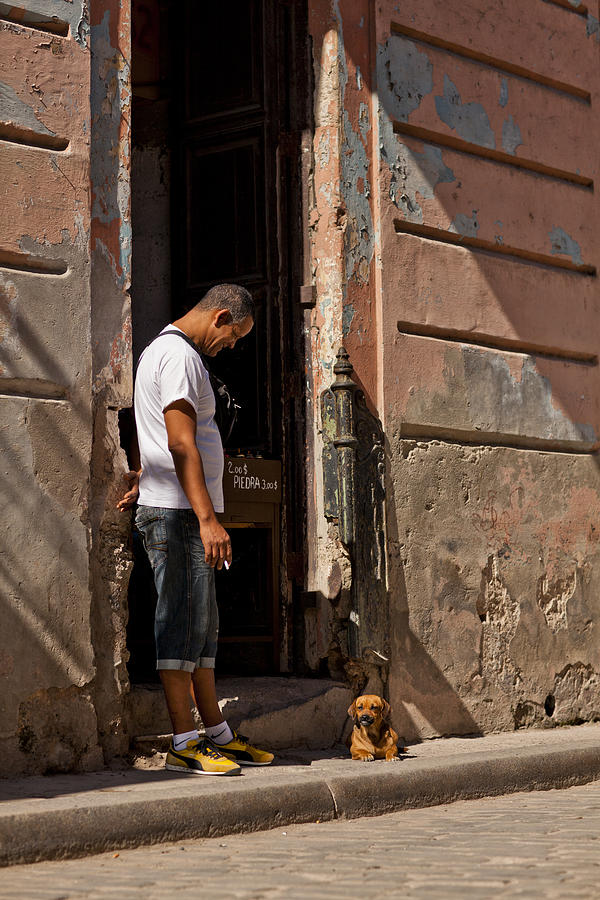 Man looking at dog in doorway Photograph by Merten Snijders