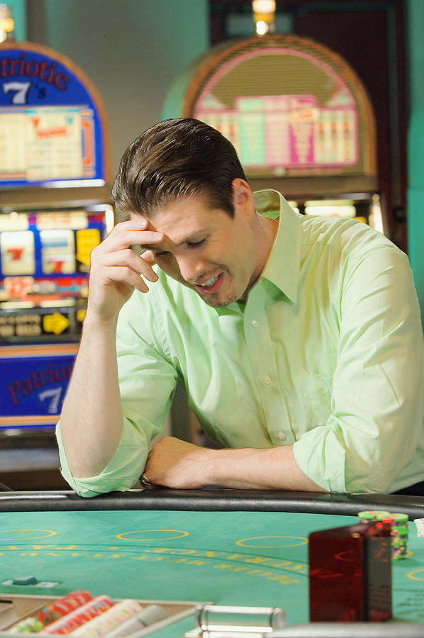 Man losing at gambling table Photograph by Jupiterimages