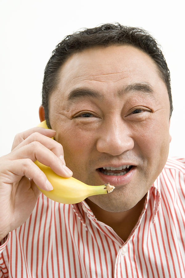 Man making a phone call using banana Photograph by Tagstock1