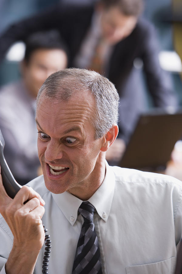 Man making faces at a phone Photograph by Comstock Images