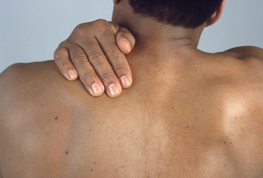 Man massaging his shoulder blade Photograph by Fotokia