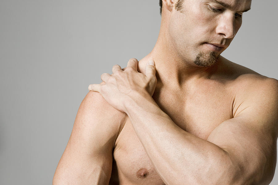 Man massaging shoulder Photograph by Photodisc