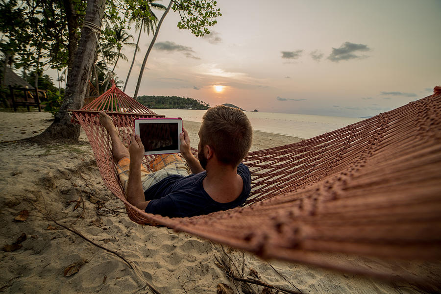 Man on hammock relaxing-Digital tablet Photograph by Swissmediavision