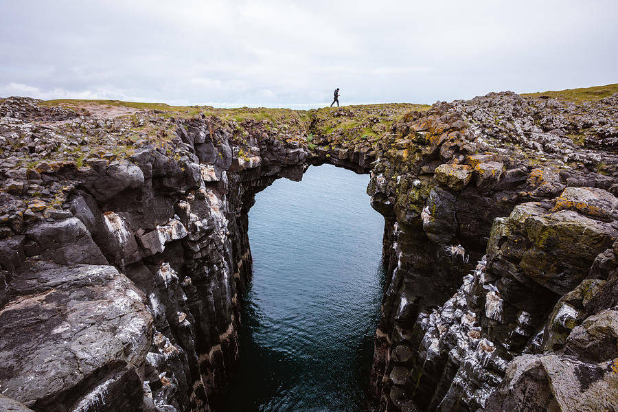 Man on top of natural rocky arch, Snaefellsnes, Iceland Photograph by Matteo Colombo