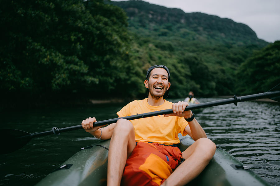 Man paddling kayak in mangrove river and laughing, Iriomote, Japan Photograph by Ippei Naoi