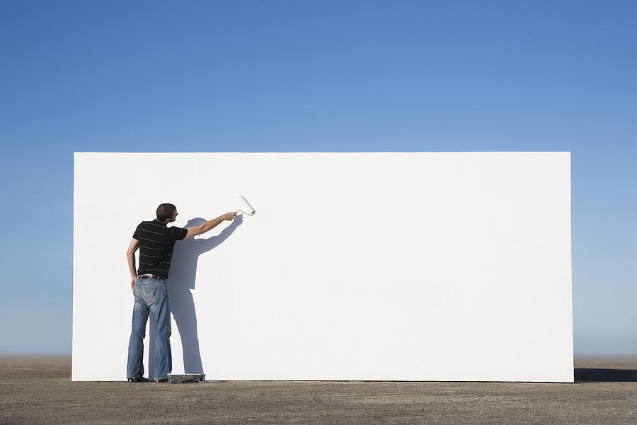 Man painting wall outdoors Photograph by Martin Barraud