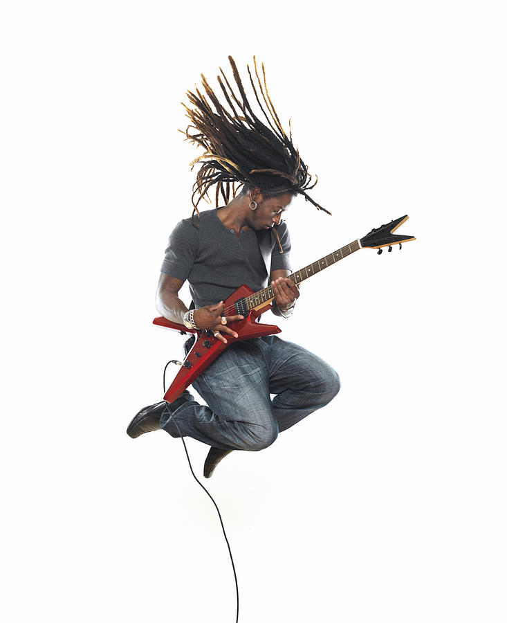 Man playing electric guitar and jumping Photograph by Lisegagne