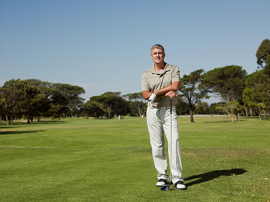 Man playing golf on golf course Photograph by Image Source