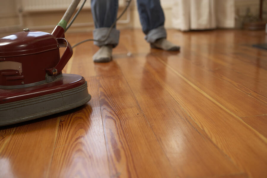 Man polishing wooden floor, low section Photograph by Ableimages