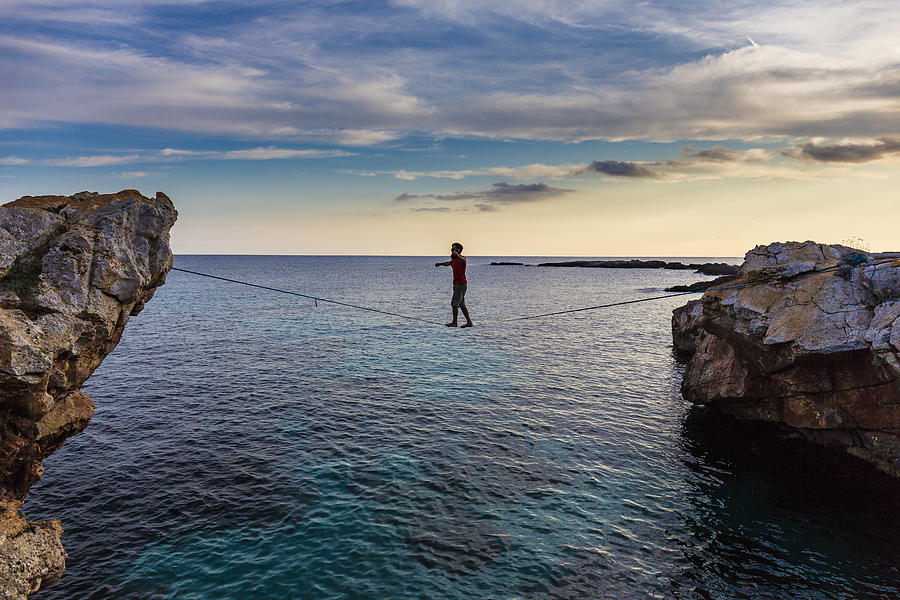 Man practicing slackline over the sea Photograph by Aluxum