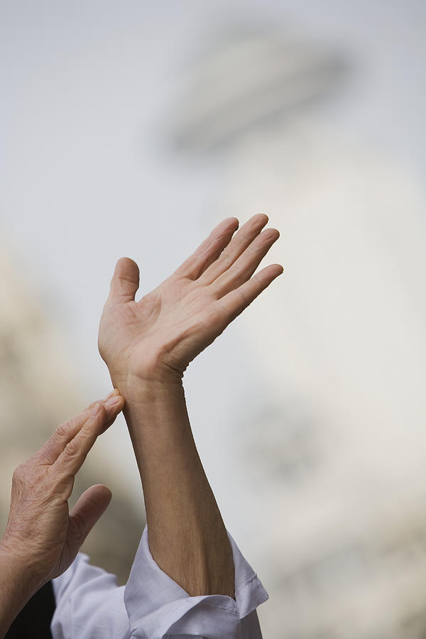Man practising Tai chi at street, close-up of hands Photograph by John W Banagan