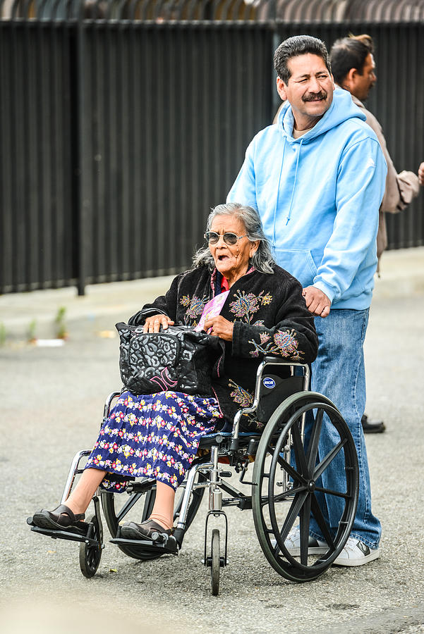 Man pushing wheelchair with disabled senior woman Photograph by Anouchka