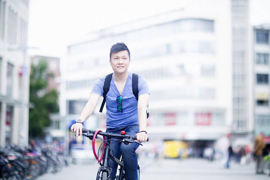 Man riding bicycle in city Photograph by Sigrid Gombert