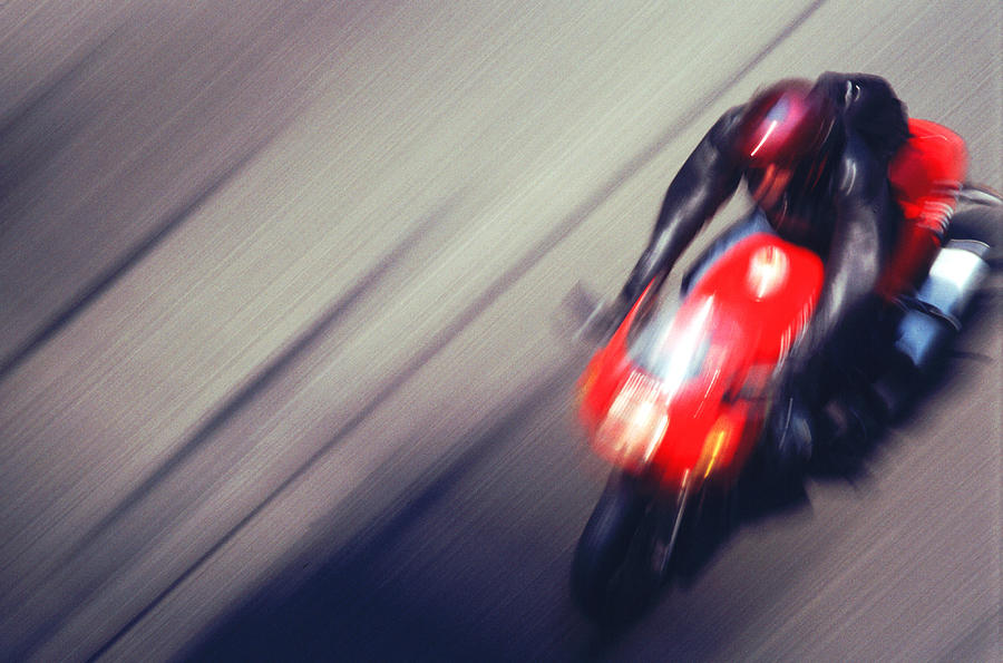 Man riding motorbike on street (blurred motion) Photograph by John Foxx