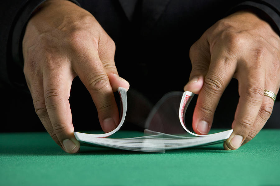 Man shuffling deck of cards, close-up Photograph by Carlos Davila