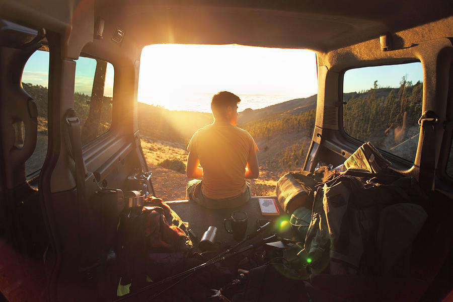 Man sitting in car looking at sunset in mountains Photograph by Stanislaw Pytel
