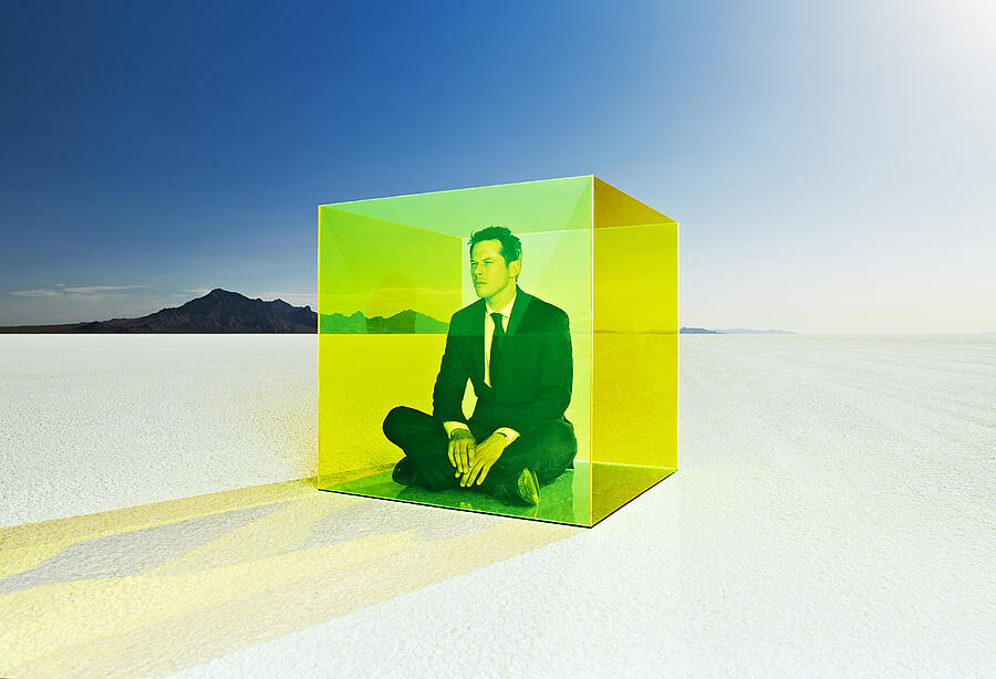 Man sitting in colored box on salt flats. Photograph by Andy Ryan